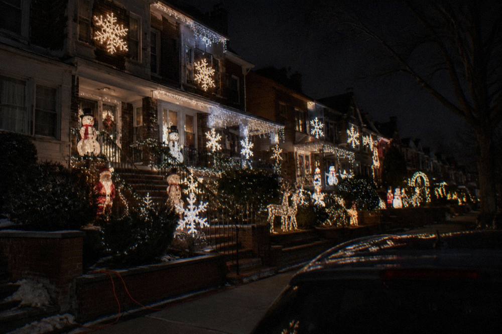 Row of Brooklyn houses covered in oversized illuminated holiday figures and string lights