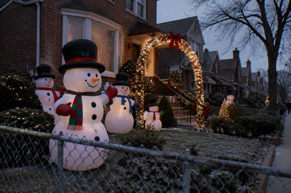 Inflatable snowmen and glowing light arches on a Brooklyn residential street