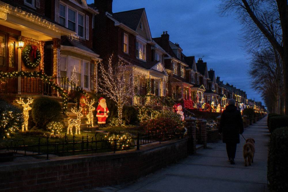 Rows of Brooklyn houses covered in oversized illuminated holiday decorations