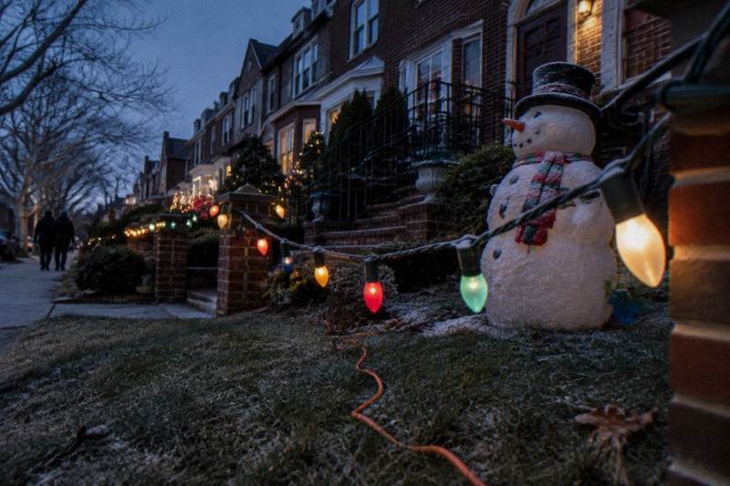 Colorful Christmas lights covering decorated Brooklyn homes at night in Dyker Heights