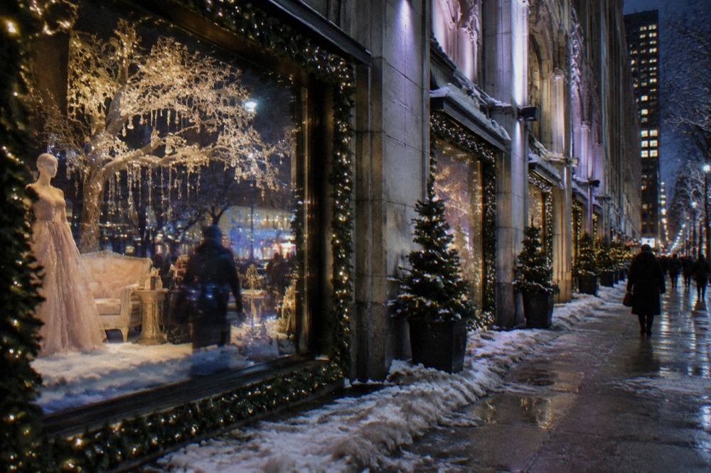 Ornate holiday window display with lit decorations behind glass on a Manhattan avenue
