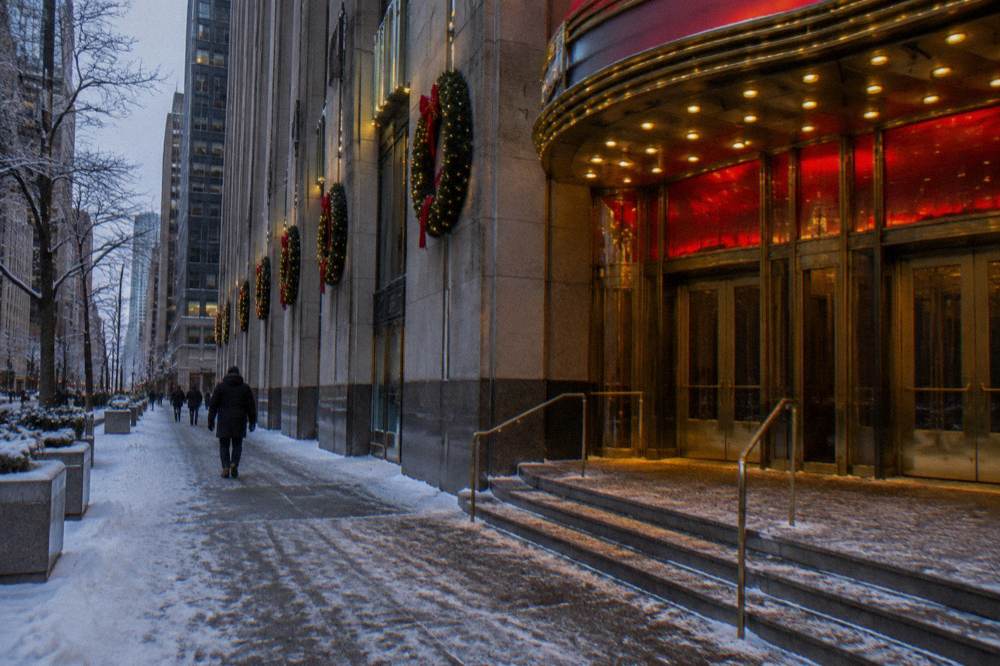 Radio City Music Hall marquee lit at night with the exterior of the Art Deco building decorated for the holiday season