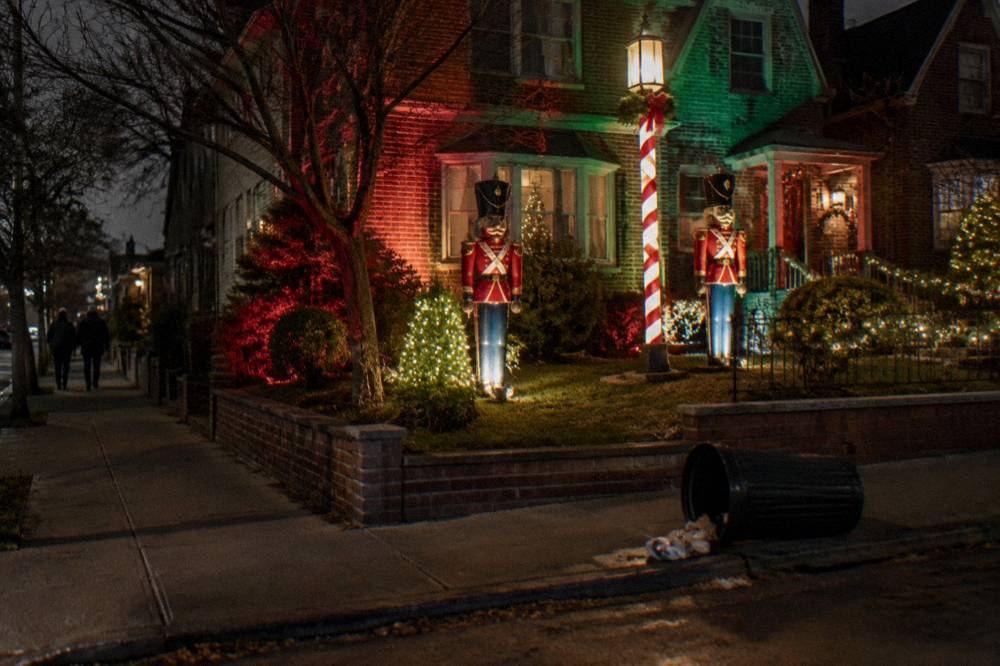 A decorated street corner in Dyker Heights with illuminated toy soldiers and holiday lights