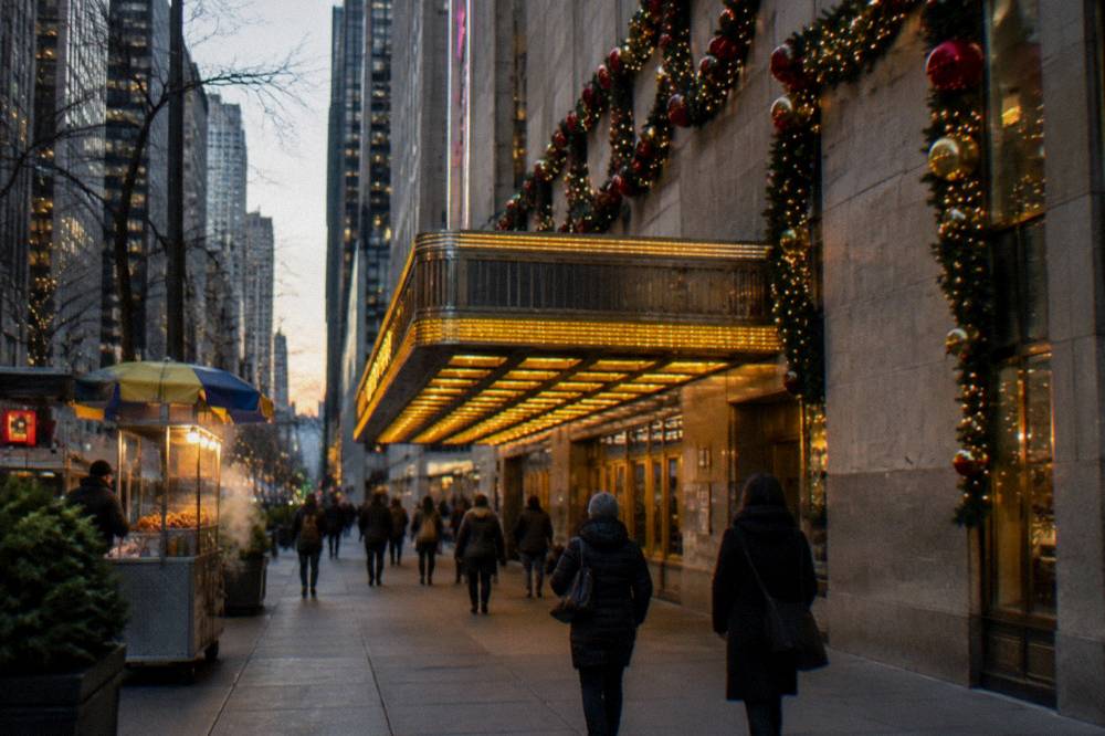 A historic theater marquee lit for the holidays on a Midtown Manhattan avenue