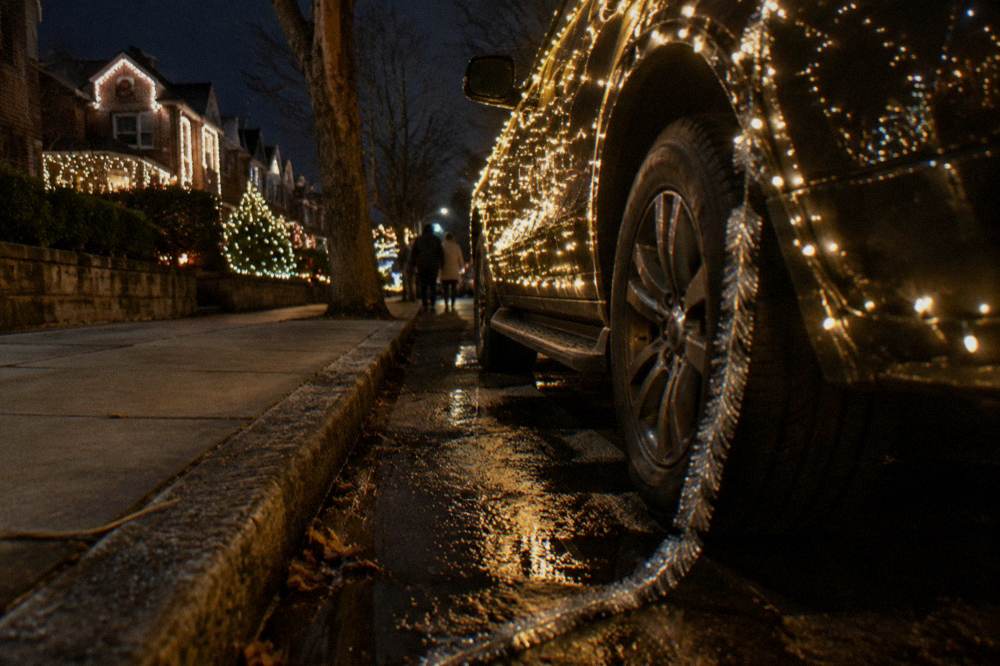 Illuminated private vehicle parked on a decorated residential Brooklyn block at night
