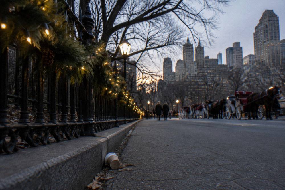 Holiday lights and festive street decorations along Central Park South at evening