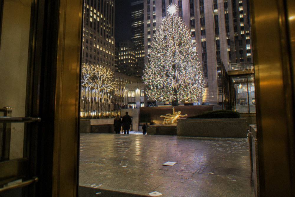 The Rockefeller Center Christmas tree glowing above the plaza at night